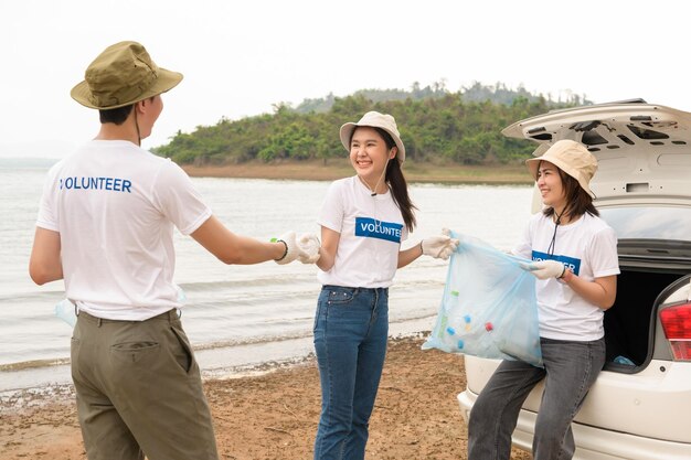 Volunteers from the Asian youth community using rubbish bags cleaning up nature par