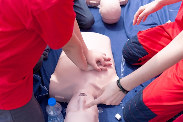 Photo volunteers giving first aid training with mannequin