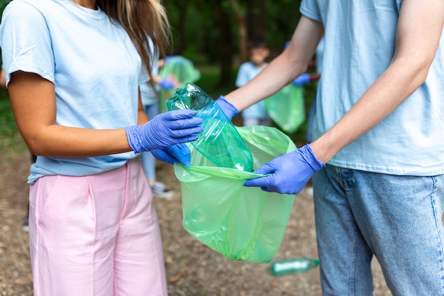 ボランティアが自然の中でプラスチック廃棄物を拾っています公園でゴミを集めている活動家