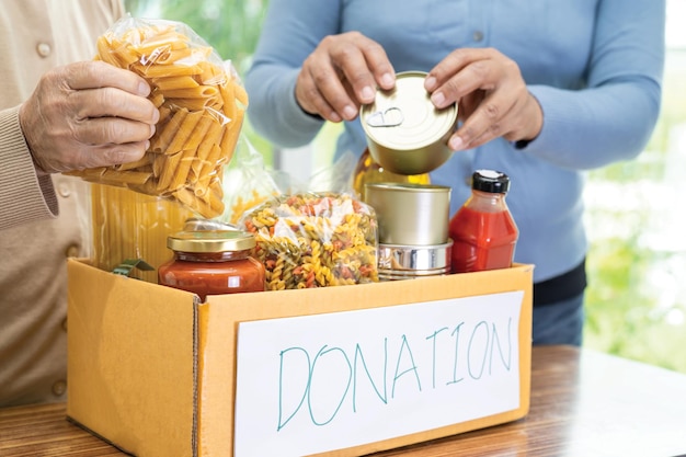 Volunteers putting various dry food in donation box for help people