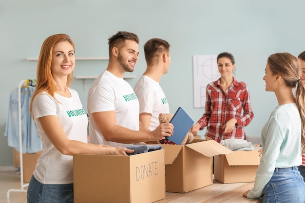 Volunteers with donations for poor people indoors