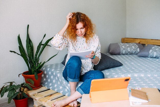 Foto volwassen aantrekkelijke vrouw die thuis studeert op online cursussen met behulp van een tablet