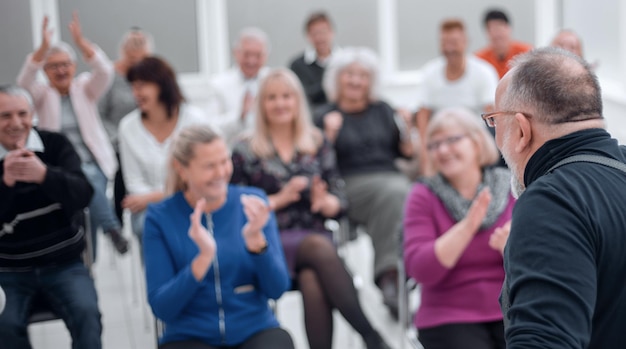 Volwassen blanke man houdt een toespraak tijdens een vergadering in een modern open kantoor