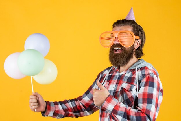 Volwassen knappe man in geruit hemd met feestballonnen verjaardag