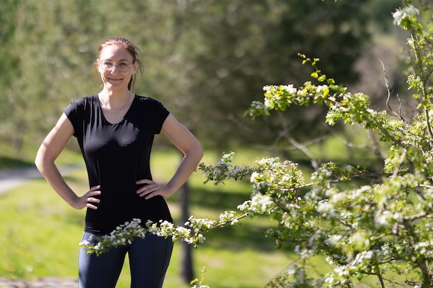 Volwassen lachende vrouw in sportkleding op de natuur