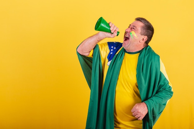 Volwassen man brazilië voetbalfan met vlag schreeuwen promotie met mega telefoon