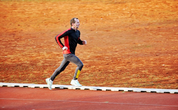 Volwassen man die op een atletiekbaan loopt en het concept van gezond en recreatie vertegenwoordigt