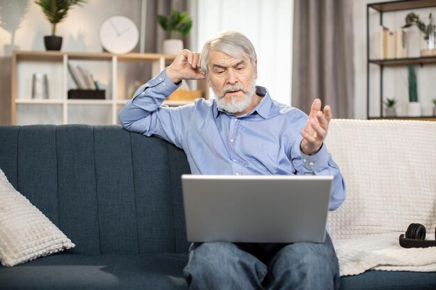 Volwassen man die thuis online films kijkt via een laptop