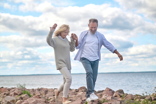 Volwassen man en vrouw die aan de kust lopen