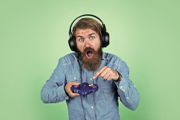 Volwassen man gamer speelt computerspelletjes kerel met baard die videospelletjes speelt brutale kaukasische hipster met snor ontspannen thuis console controller joystick gamen in oortelefoons