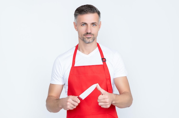 Volwassen man kok in schort met scherp mes op witte achtergrond