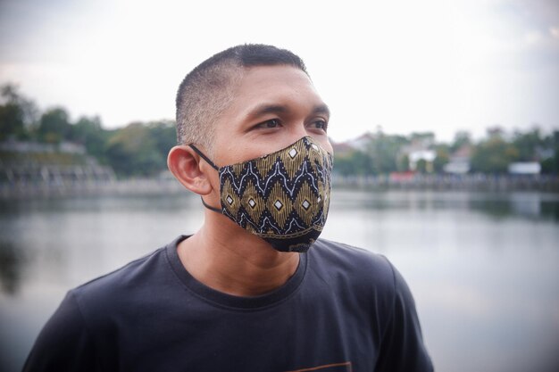 Foto volwassen man met een masker met batikpatroon