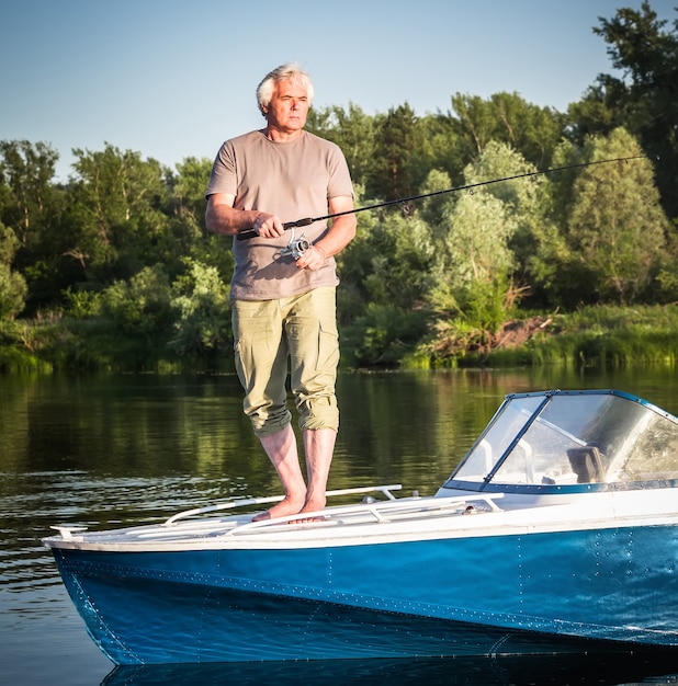 Volwassen man op een motorboot. Vissen.