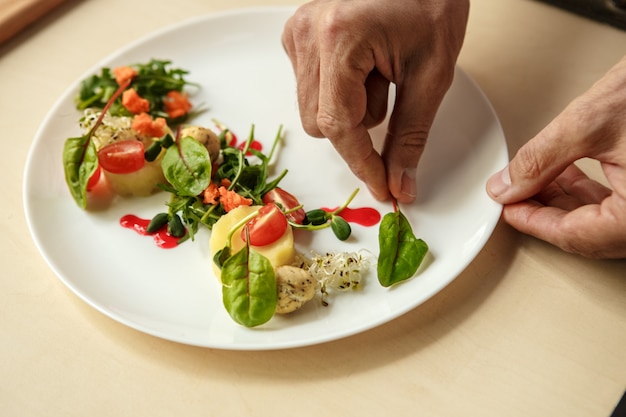 Volwassen man professionele chef-kok koken maaltijd binnenshuis