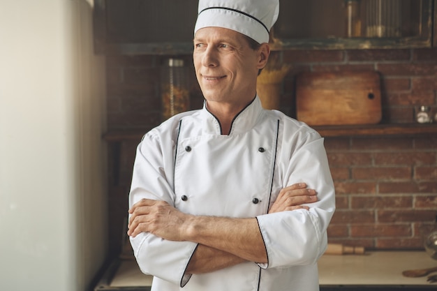 Volwassen man professionele chef-kok koken maaltijd binnenshuis