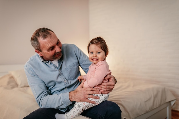 Foto volwassen man zittend op een bed met een babymeisje