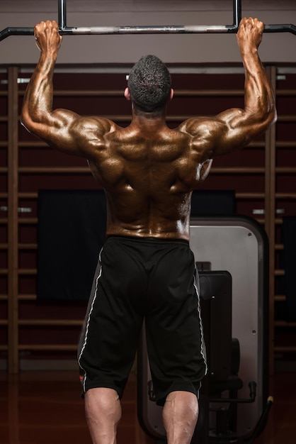 Volwassen mannelijke atleet doet pull-ups Chin-ups in de sportschool Beste oefening voor rug