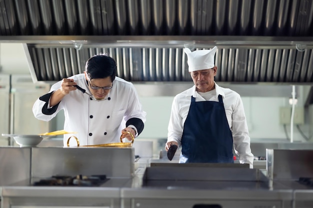 Volwassen meesterkok en student Kookcursus portret senior Aziatische Thaise mannelijke professionele kok kok koken maaltijd culinaire klas kookcursus lessen in een kookschool