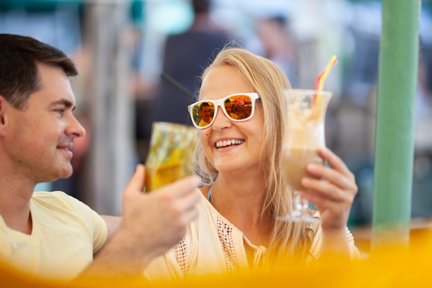 Volwassen paar dat pret heeft bij de bar, cocktails