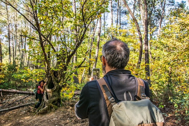 Volwassen paar wandelen in een natuurreservaat en foto's maken met een smartphone.