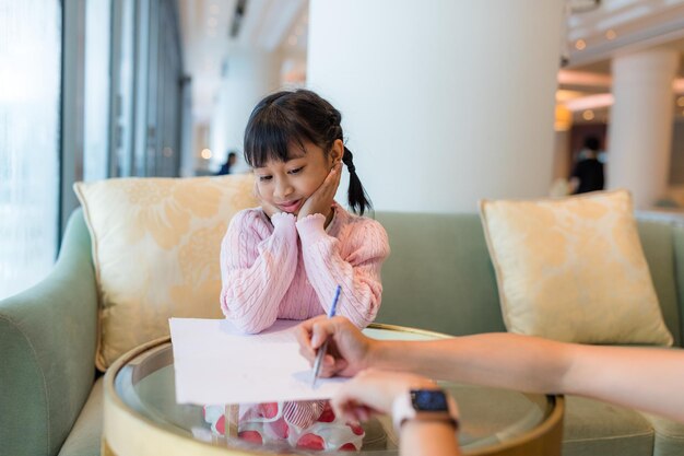 Volwassen spel met kind meisje schrijven op papier