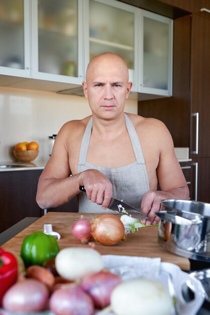 Volwassen sterke man in de keuken bereiden van voedsel