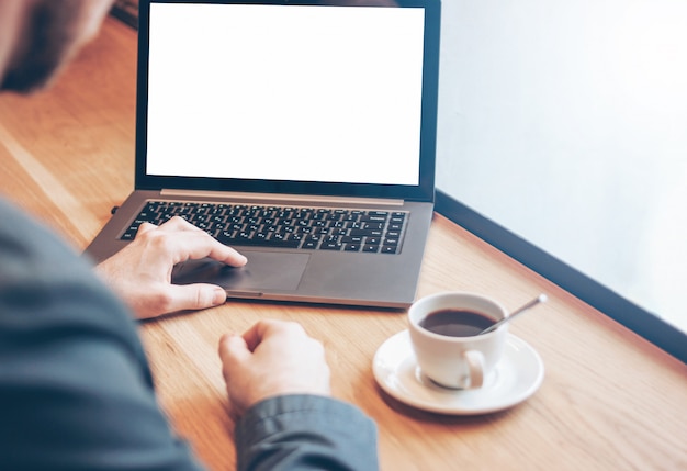 Volwassen succesvolle kale bebaarde man in pak met laptop in café