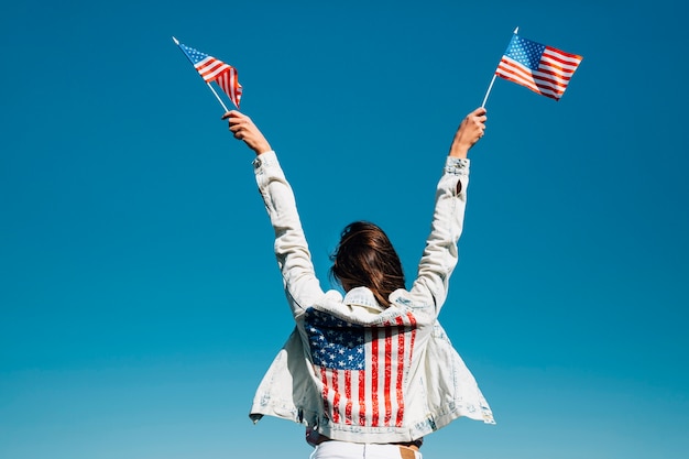 Foto volwassen vrouw die handen met amerikaanse vlaggen opheft