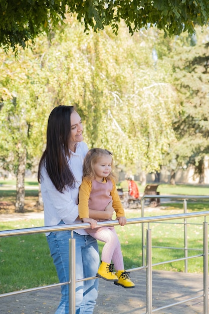 Volwassen vrouw die plezier heeft met haar kinddochter in groen park