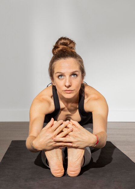 Foto volwassen vrouw doet yoga thuis