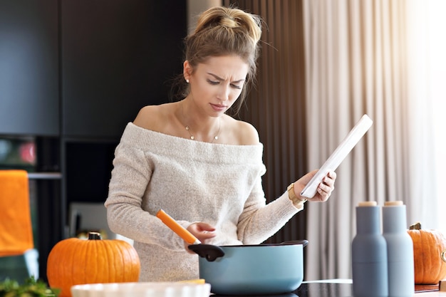 volwassen vrouw in de keuken die pompoengerechten klaarmaakt voor Halloween