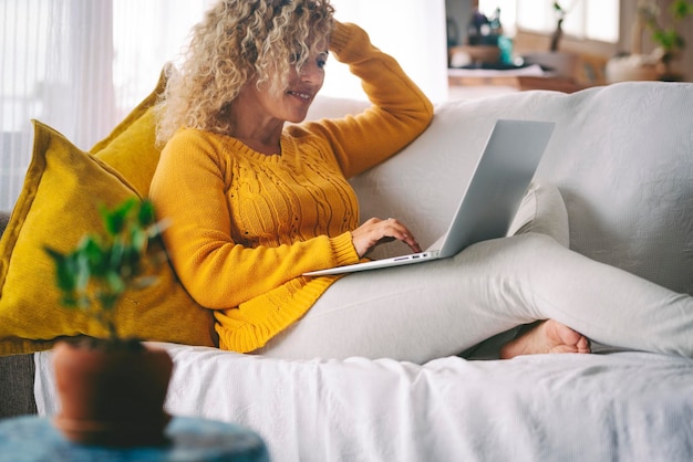 Volwassen vrouw in indoor home technologie vrijetijdsbesteding met behulp van laptopcomputer om op het web te surfen en te glimlachen online baan zakelijk werk gelukkige vrouwelijke mensen in video-oproepverbinding