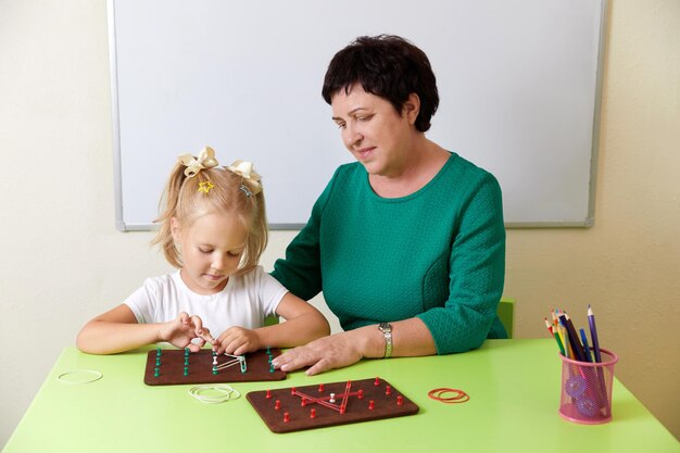 Volwassen vrouw leert kind het alfabet ontwikkeling van fijne motorische vaardigheden concept
