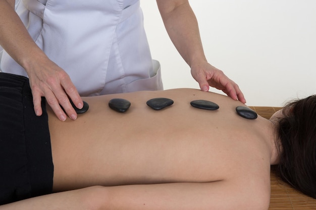 Volwassen vrouw met hotstone-massage in spa salon