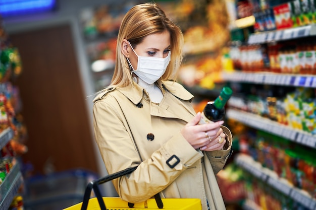 volwassen vrouw met medisch masker boodschappen doen