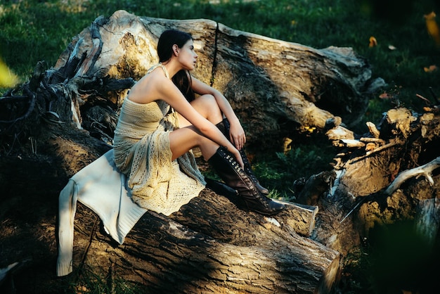 Volwassen vrouw ontspannen zittend op hout in een openlucht park sensueel model meisje met gladde huid en makeu