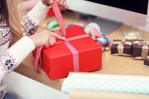 Foto volwassen vrouw thuis kerstcadeautjes inpakken