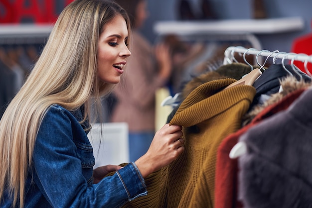 volwassen vrouw winkelen voor kleding in het stadscentrum in de herfst