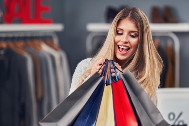 Volwassen vrouw winkelen voor kleding in het stadscentrum in de herfst