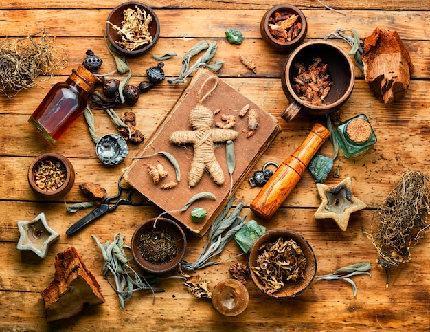 Voodoo doll, magical herbs and witchcraft attributes on an old table