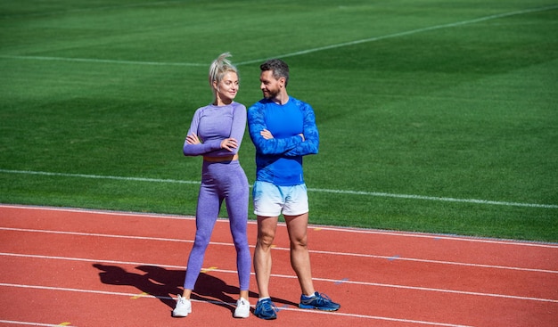 Voor de training is atleet en sportman sport paar goede team fitness partners atletische man en vrouw ontspannen na race mannelijke en vrouwelijke coach op stadion atletiekbaan arena gezonde levensstijl