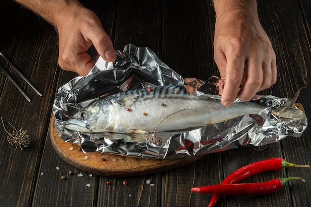 Voor het bakken moet verse vis in foliehanden worden gewikkeld tijdens het koken van heerlijke makreel