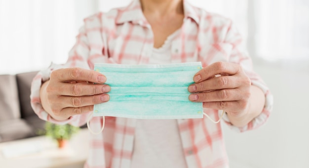 Foto vooraanzicht dat van oudere vrouw medisch masker steunt