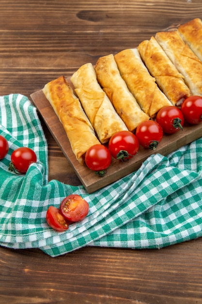 vooraanzicht gebakken groen gebak met rode tomaten op bruine achtergrond koken gebak vlees bakken diner eten