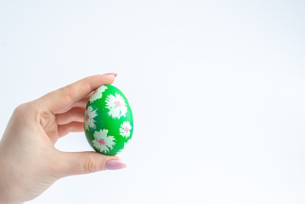 vooraanzicht groen ontworpen ei in vrouwelijke hand op witte achtergrond lente kleurrijke horizontale novruz concept sierlijke