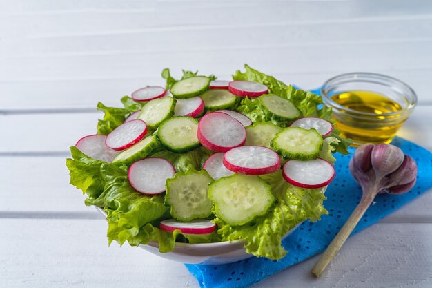 Vooraanzicht Groentesalade met radijs, komkommer en sla in een slakom, plat leggen.