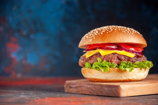 Vooraanzicht heerlijke cheeseburger met vleestomaten en groene salade op donkere achtergrond sandwich fastfood maaltijd snack frietjes diner schotel