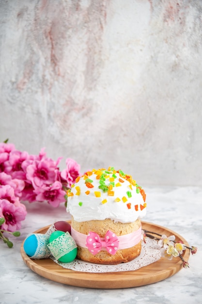 vooraanzicht heerlijke paascake met gedroogde vruchten en gekleurde eieren op wit oppervlak concept dessert kleur kleurrijke sierlijke taart
