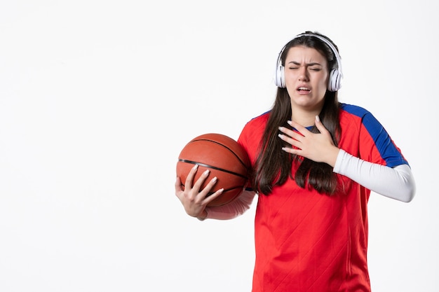 Vooraanzicht jong wijfje in sportkleren met basketbal