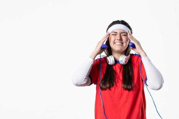 Vooraanzicht jong wijfje in sportkleren met springtouwen op witte muur